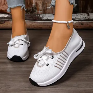 Detail view of white breathable mesh slip-on sneakers with comfortable thick soles.