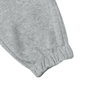 Gedetailleerd aanzicht van elastische manchetten op grijze heren joggingbroek met fleece.