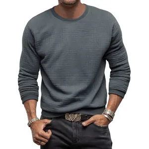 Détail d'un t-shirt à manches longues en tricot gaufré gris pour homme, coupe ajustée.