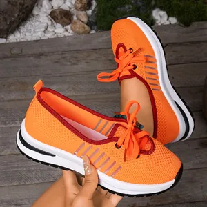 Close-up of breathable orange fly-knit walking shoes with lightweight non-slip soles