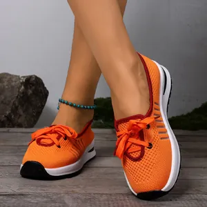 Detail view of orange breathable mesh slip-on walking sneakers for elderly women