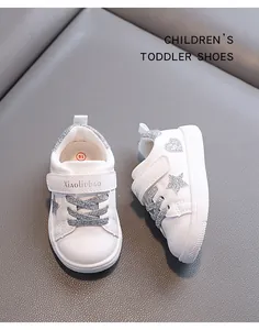 Detailed view of toddler white sneakers featuring silver glitter stars and heart