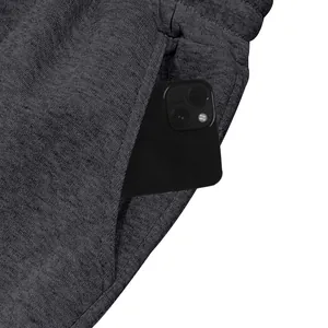 Detail van een diepe zijzak van een antracietgrijze fleece joggingbroek met smartphone