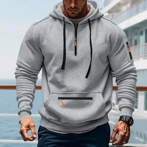 Detailansicht eines grauen Sweatshirts mit Halbreißverschluss und orangefarbenen Zippern