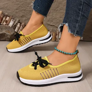 Macro view of breathable yellow fly-knit mesh sneakers with lightweight slip-on design