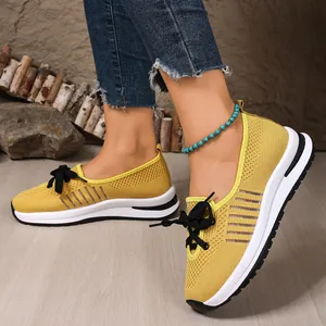 Detailed view of yellow breathable flyknit walking shoes worn with turquoise anklet