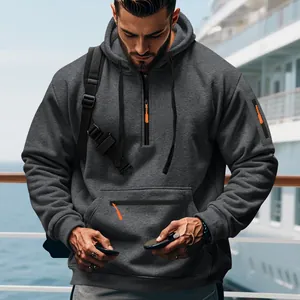Detailansicht eines schweren dunkelgrauen Fleece-Hoodies mit orangen Kontrast-Reißverschlüssen.