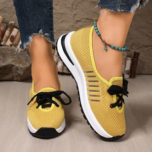 Detailed close-up of yellow breathable flyknit walking sneakers with mesh texture
