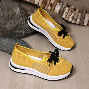 Detailed view of yellow breathable mesh slip-on walking shoes with stylish black laces