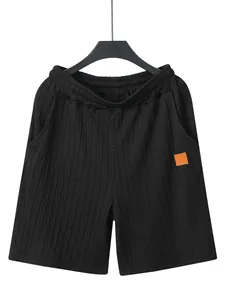 Detail von schwarzen Herren-Freizeitshorts mit Zopfstrickmuster und orangefarbenem Patch