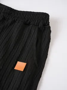 Detailansicht der schwarzen Herren-Sportshorts mit einzigartiger Zopfstrickstruktur