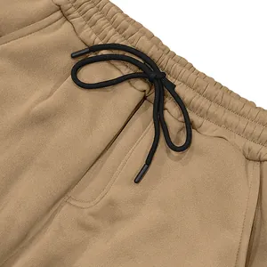 Detailopname van de elastische tailleband met zwart trekkoord op een kaki heren vrijetijdsbroek