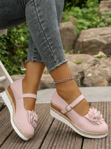 Vista detallada de zapatos Mary Jane rosas con flores y suela de cuña de alpargata