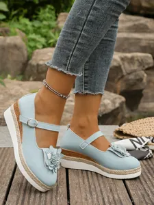 Vista de detalle de zapatos Mary Jane azul claro con flor 3D y suela de cuerda trenzada