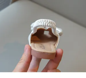 Detail view of white girls' bow sandals showing the comfortable elastic heel strap and soft insole