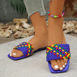 Detailed close-up view of colorful woven square-toe flat sandals in trendy street style design