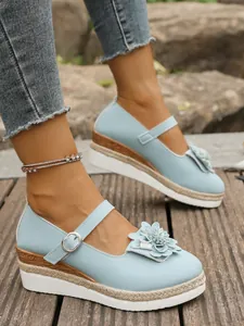 Detalle de zapatos con plataforma azul claro con flores y una suela de esparto