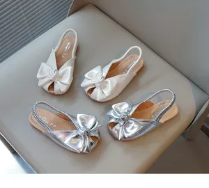 Elegant girl's sandals with large decorative bows in silver and off-white pearl colors