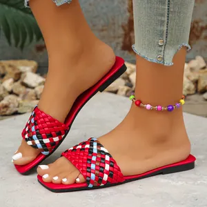Stylish women's square toe flat sandals with colorful woven straps shown on feet.
