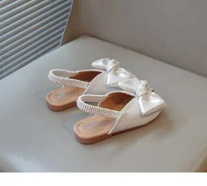 Detailed rear view of white girls' bowknot sandals featuring elastic back straps