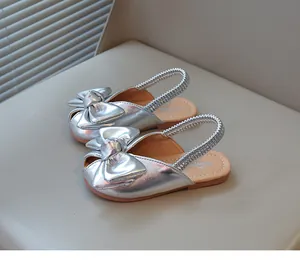 Detailed view of fashionable silver girls' princess sandals with a large decorative bow