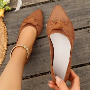 Dettaglio delle ballerine in maglia traspirante marrone con elegante fiocco