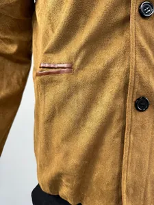 Detailed close-up of a brown suede work jacket showing pocket trim and button texture