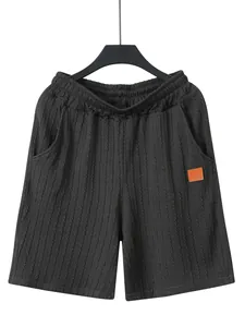 Nahaufnahme der dunkelgrauen Strickshorts mit Gummibund und Lederaufnäher am Bein