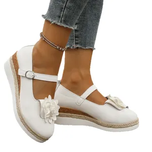 Mary Janes blancas con plataforma y cuña, flores decorativas y suelas envueltas en yute.