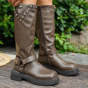Detailansicht brauner mittelhoher Plateaustiefel mit herzförmiger Schnalle und Nieten.