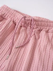 Detailansicht des rosa Strickbunds mit verstellbarem Kordelzug und Metallspitzen