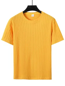 Nahaufnahme eines hellgelben Kurzarm-T-Shirts mit Zopfmuster und sichtbarem Kragenetikett