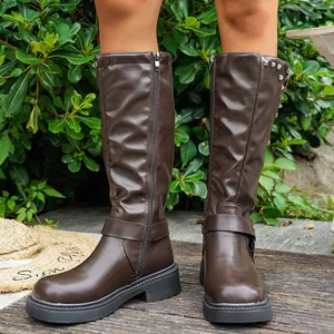 Nahaufnahme dunkelbrauner kniehoher Damenstiefel mit Reißverschluss und dekorativen Nieten
