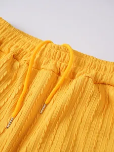 Nahaufnahme von lebhaft gelben Herrenstrickshorts mit Zopfmuster und Kordelzugdetail