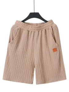 Detailansicht der beigefarbenen Herren-Strickshorts mit elastischem Bund und Logo-Patch