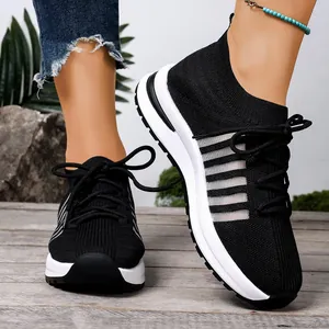 Κοντινό πλάνο σε μαύρα αθλητικά παπούτσια fly-knit με λευκή σόλα πλατφόρμα.