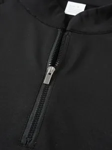 High-quality close-up of the silver zipper and stand collar on black athletic sweatshirt.