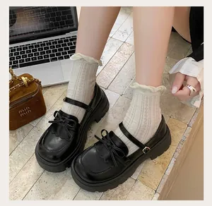 Detailed view of black platform Mary Jane shoes featuring elegant bow knots and thick soles