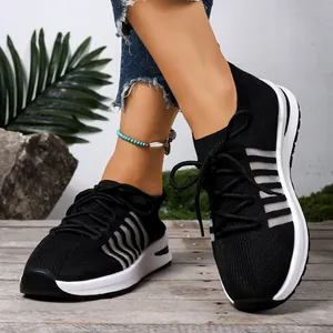 Λεπτομέρεια από μαύρα flyknit παπούτσια με λευκές σφήνες σόλες σε ξύλινο πάτωμα