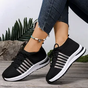Λεπτομερής όψη των μαύρων fly-knit sneakers με πλατφόρμα και κομψές πλαϊνές ρίγες