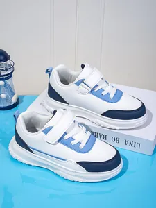 Detailansicht der weiß-blauen Kinder-Sportschuhe in einem sauberen Studio-Setting.