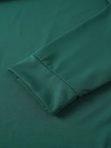 Detail of dark green men's sports shirt cuff showing soft fabric texture and clean stitching.