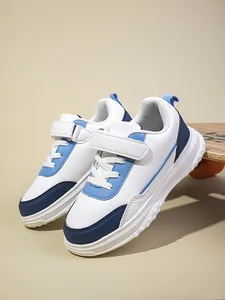 Modische weiß-blaue Kindersneaker präsentiert auf einem stabilen Holz-Skateboard