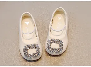 Detailed view of cream-colored toddler girl flats featuring a sparkling rhinestone buckle.