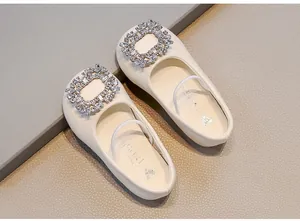 Detailed view of cream girls' soft leather flats with sparkling rhinestone square buckle
