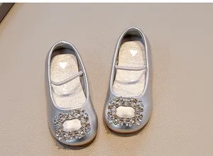 Close-up of silver girls' soft leather ballet flats with sparkling rhinestone buckle