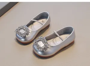 Detail of silver baby girl leather shoes featuring sparkling rhinestone buckles