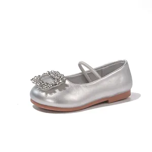 Profile view of shiny silver girl's flat shoe featuring a square rhinestone buckle