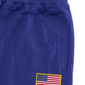 Detailopname van blauwe mesh joggingbroek met geborduurde Amerikaanse vlag patch