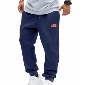 Detail van een donkerblauwe joggingbroek voor heren met Amerikaanse vlag patch.